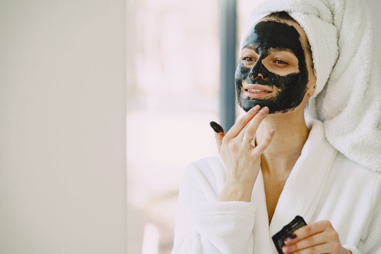 Woman applying a skincare routine at home with face mask