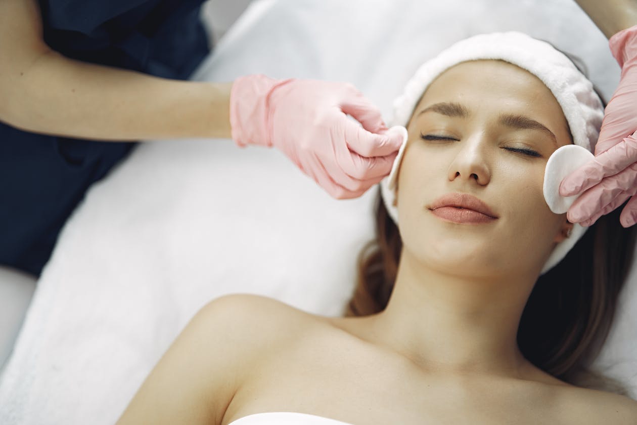 Woman getting professional spa facial treatment receiving personalized skin care